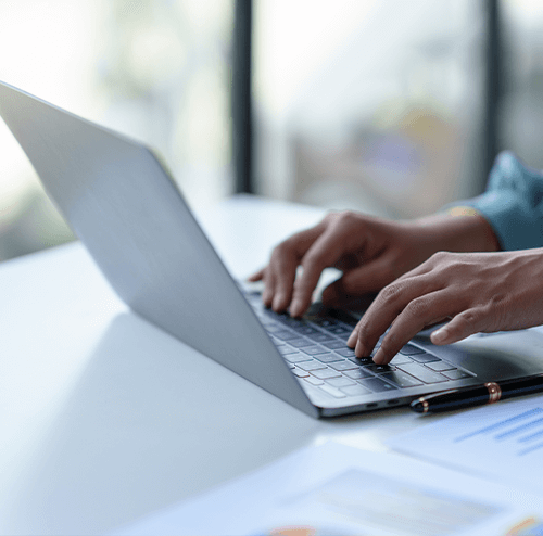 Healthcare professional typing on a laptop, efficiently managing patient care and foot health at Foot & Ankle Center of Arizona.